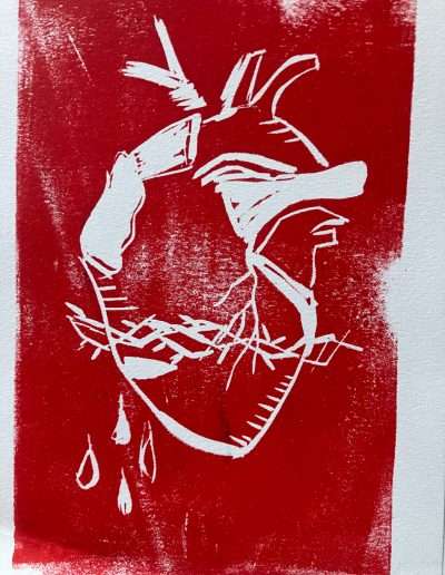 White anatomical heart with barbed wire on a red textured background.