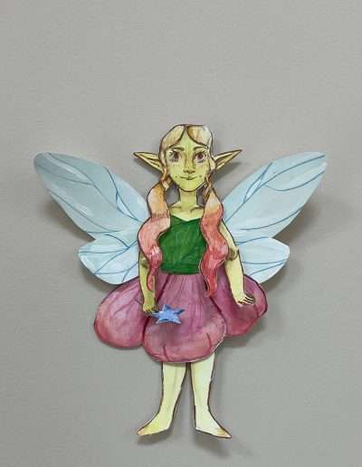 paper doll of a yellow fairy in a pink and green flower dress,, with blue wings and orange ombre hair.